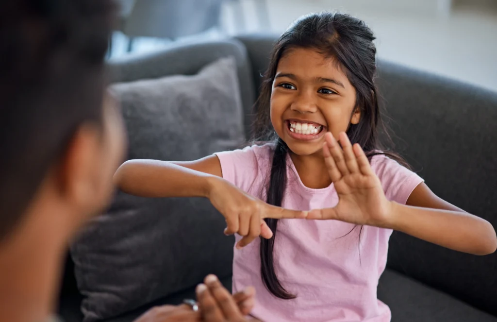 Child using sign language to communicate with parent