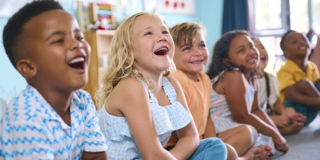 Elementary School Students Sitting On Floor During Classroom Lesson